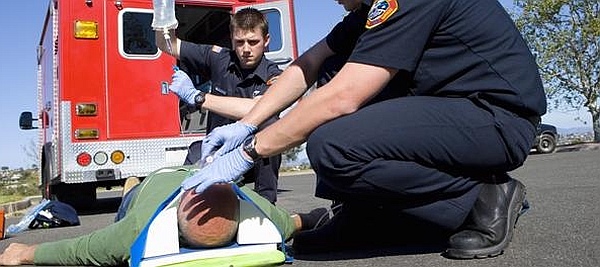 EMTs treating an injured passenger in a car accident