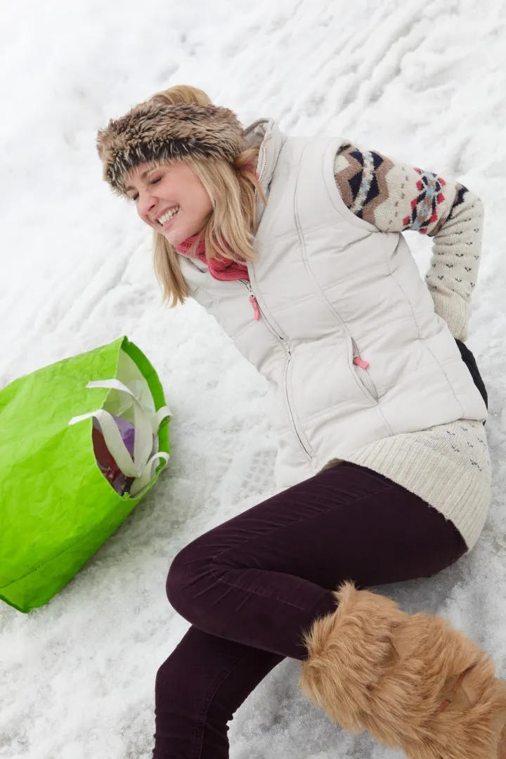 A woman has slipped and fallen into the snow.
