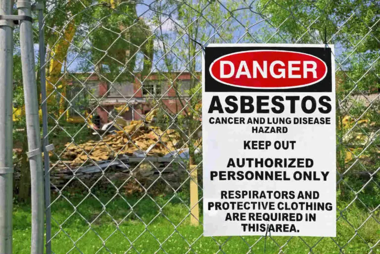 A sign on a gate warns people that asbestos is within the perimeter.