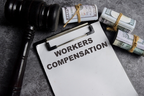 Gavel and money on paperwork labeled workers’ compensation after a Charlotte workers’ compensation accident