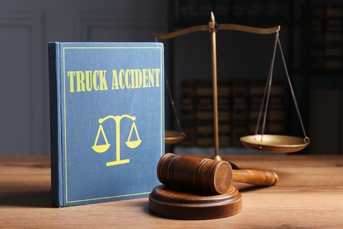 Truck accident law book with a gavel beside it, representing Asheville truck accident lawyer resources and legal action.