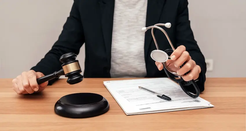 A legal professional is holding a gavel and a stethoscope symbolizing personal injury lawyers who handle medical negligence claims at 1 Charlotte Injury Lawyers in North Carolina.