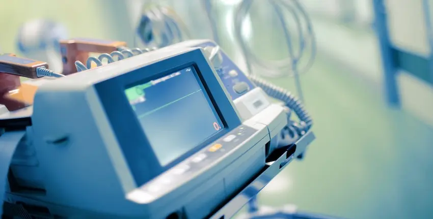 A hospital defibrillator machine with a monitor displaying a flatline in a medical facility represents the type of fatal medical emergency that may warrant consultation with a wrongful death attorney from 1 Charlotte Injury Lawyers in North Carolina.