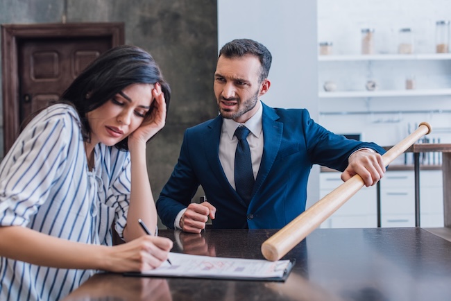 Insurance adjuster at desk reviewing settlement offers and claim documentation