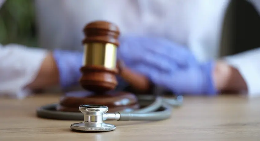 A judge’s gavel and stethoscope in front of a blurred injured patient- representing how a personal injury lawyer handles medical-related injury cases in North Carolina.
