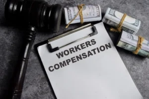 Gavel and money on paperwork labeled workers’ compensation after a Charlotte workers’ compensation accident