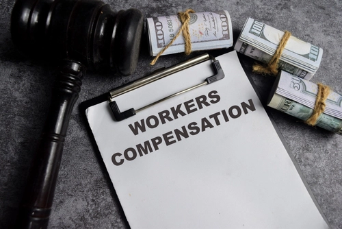 Gavel and money on paperwork labeled workers’ compensation after a Charlotte workers’ compensation accident