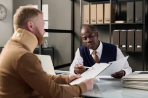 Workers compensation claims assistance attorney reviewing documents with injured worker in Charlotte office