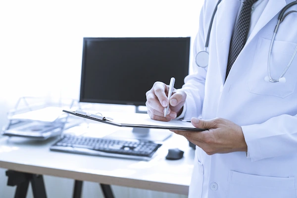 A doctor fills out medical records for a personal injury claim.